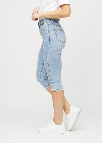 Skinnycapris för kvinnor i ljusblå denim, färgen Waves. Från sidan på en modell, med åtsittande passform.