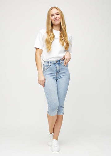 Skinnycapris för kvinnor i ljusblå denim, färgen Waves. Helbild av en modell som bär capris.