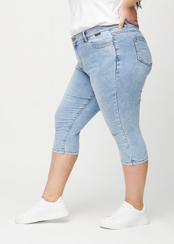 Skinnycapris för kvinnor i ljusblå denim, färgen Waves. Från sidan på en plus size-modell, med åtsittande passform.