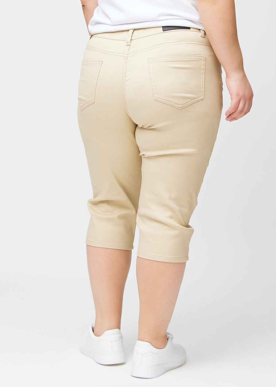 Slimcapris för kvinnor i beige jeanstyg, färgen Gazelles. Bakifrån på en plus size-modell, med fokus på passform, längd och bakfickor.