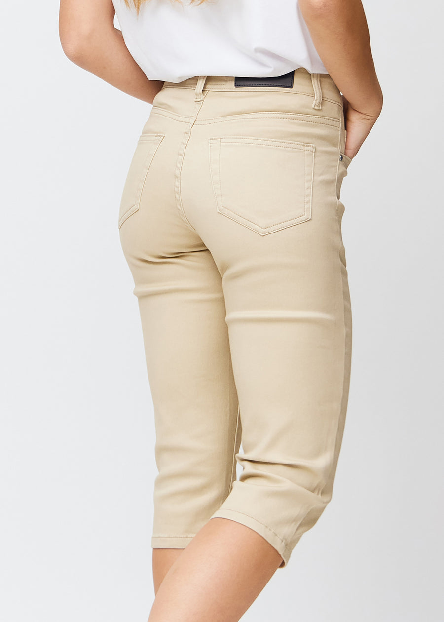 Slimcapris för kvinnor i beige jeanstyg, färgen Gazelles. Närbild bakifrån på en modell, med fokus på bakfickor och sömmar.