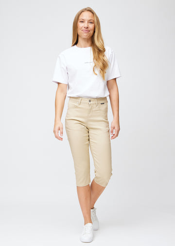 Slimcapris för kvinnor i beige jeanstyg, färgen Gazelles. Helbild av en modell som bär slimcapris.