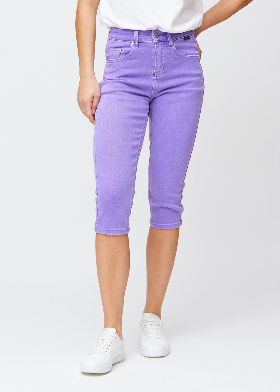 Slimcapris för kvinnor i pastellila jeanstyg, färgen Lavenders. Framifrån på en modell, med figursydd passform till strax under knät.