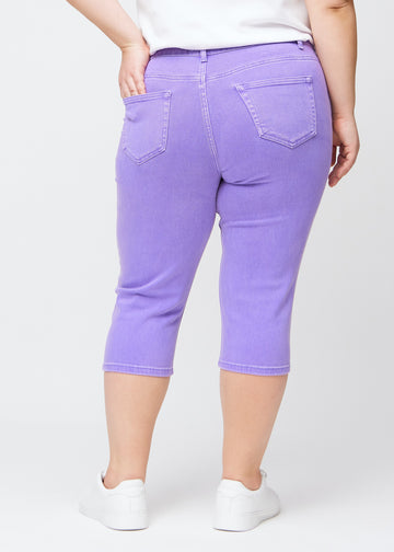 Slimcapris för kvinnor i pastellila jeanstyg, färgen Lavenders. Bakifrån på en plus size-modell, med fokus på passform, längd och bakfickor.