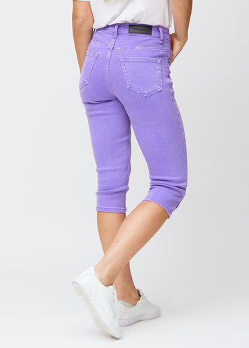 Slimcapris för kvinnor i pastellila jeanstyg, färgen Lavenders. Bakifrån på en modell, med fokus på passform, längd och bakfickor.