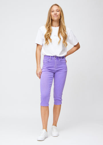 Slimcapris för kvinnor i pastellila jeanstyg, färgen Lavenders. Helbild av en modell som bär slimcapris.