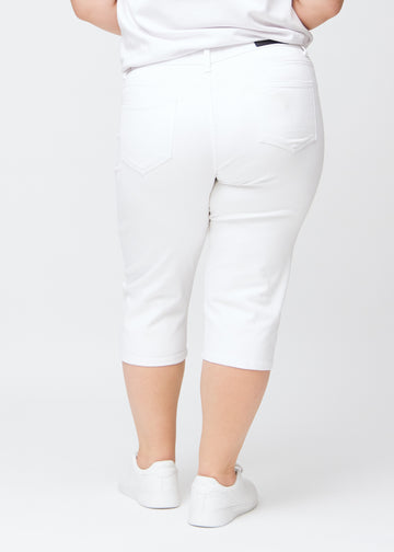 Slimcapris för kvinnor i vitt jeanstyg, färgen Marguerites. Bakifrån på en plus size-modell, med fokus på passform, längd och bakfickor.