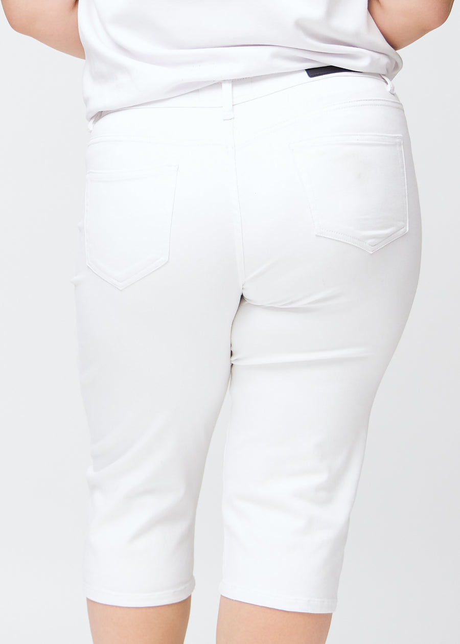 Slimcapris för kvinnor i vitt jeanstyg, färgen Marguerites. Närbild bakifrån på en plus size-modell, med fokus på bakfickor och sömmar.