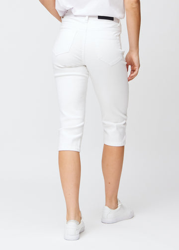 Slimcapris för kvinnor i vitt jeanstyg, färgen Marguerites. Bakifrån på en modell, med fokus på passform, längd och bakfickor.