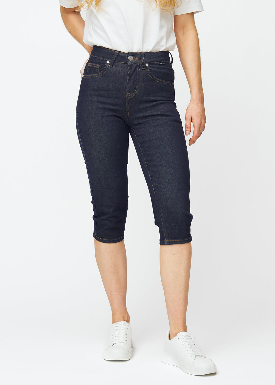 Mörkblå denim capris för dam i färgen Midnights med slim passform som är figursydd från höften till under knät, sett framifrån.