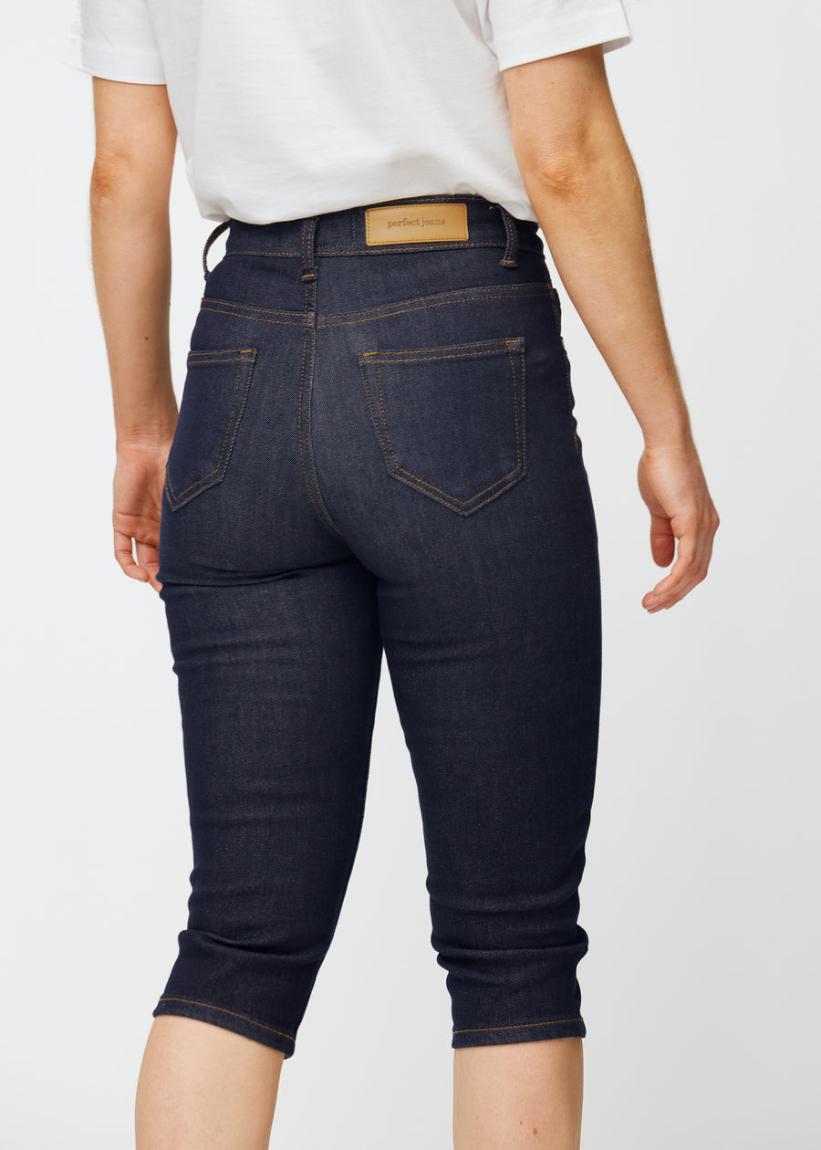 Mörkblå denim capris för dam i färgen Midnights sett bakifrån i närbild för att visa passform och detaljer.