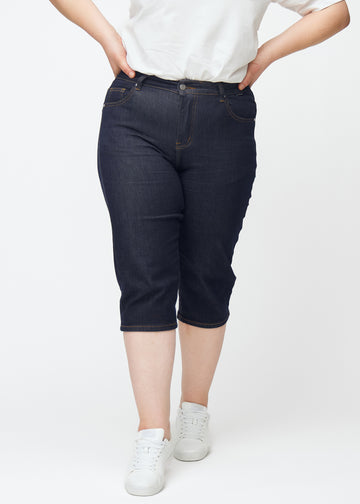 Mörkblå denim capris för dam i färgen Midnights med slim passform sett framifrån på plus-size modell.