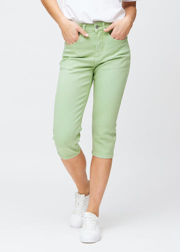 Slimcapris för kvinnor i pastellljusgrönt jeanstyg, färgen Mints. Framifrån på en modell, med figursydd passform till strax under knät.