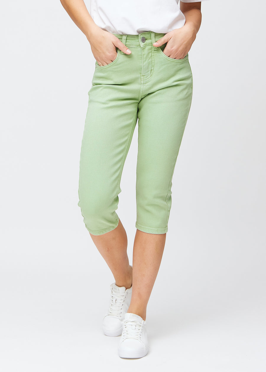 Slimcapris för kvinnor i pastellljusgrönt jeanstyg, färgen Mints. Framifrån på en modell, med figursydd passform till strax under knät.