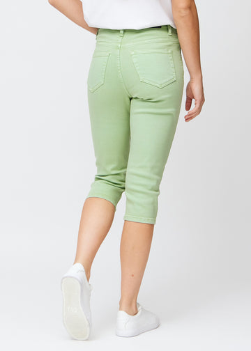 Slimcapris för kvinnor i pastellljusgrönt jeanstyg, färgen Mints. Bakifrån på en modell, med fokus på passform, längd och bakfickor.