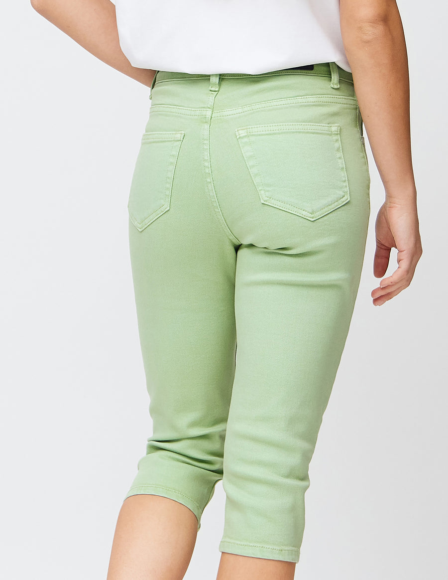 Slimcapris för kvinnor i pastellljusgrönt jeanstyg, färgen Mints. Närbild bakifrån på en modell, med fokus på bakfickor och sömmar.