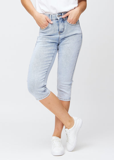 Slimcapris för kvinnor i ljusblå denim, färgen Waves. Framifrån på en modell, med figursydd passform till strax under knät.