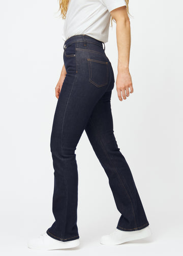 Djupt mörkblå denim jeans för kvinnor i färgen Midnights med bootcut-passform sedd från sidan på modell.