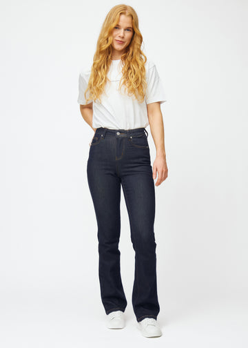 Helbild av modell i djupt mörkblå denim jeans för kvinnor i färgen Midnights med bootcut-passform.