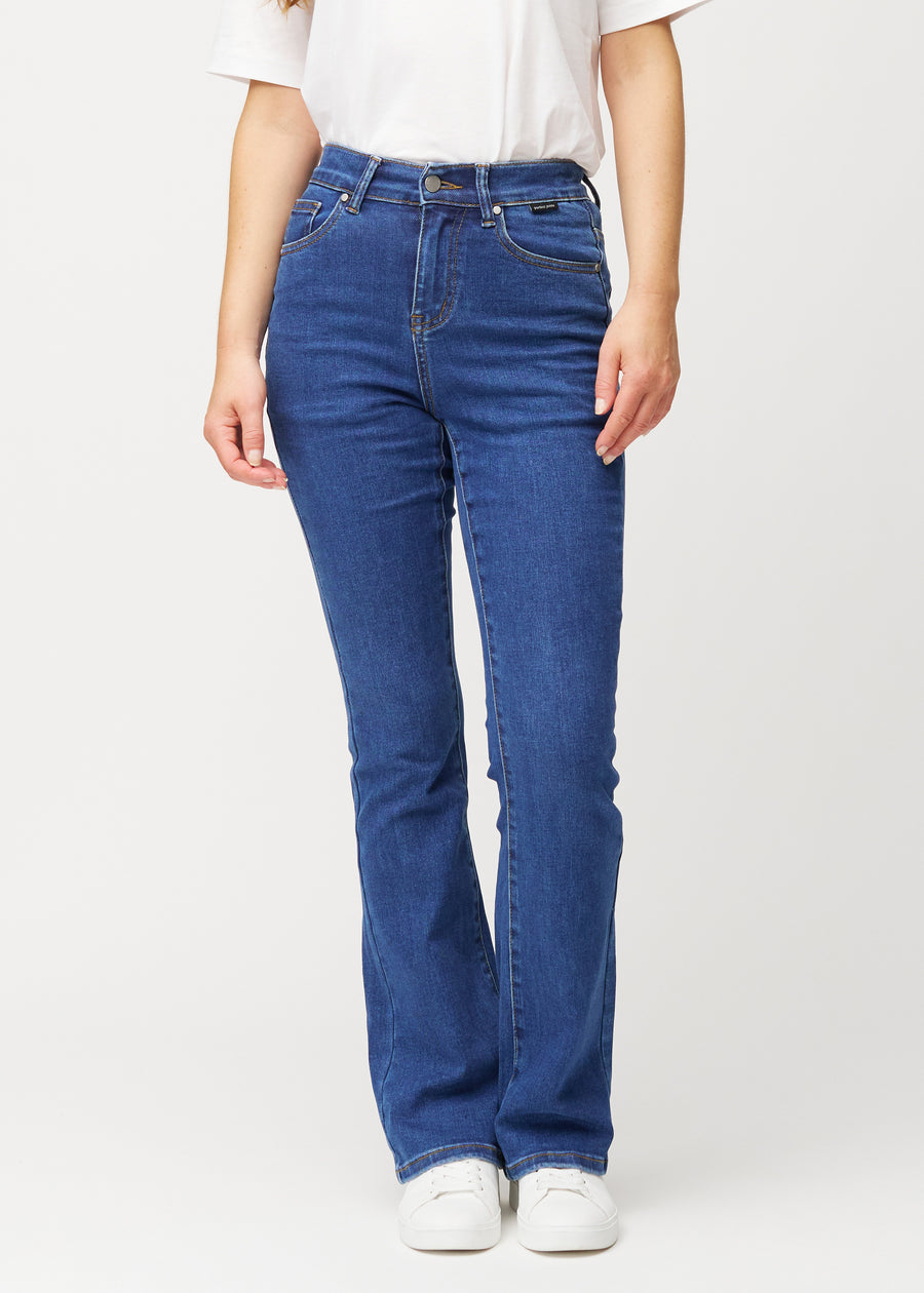 Mörkblå mid-rise bootcutjeans i färgen Oceans. Framifrån på en modell, med nära passform över höfter och lår och lätt utsvängning nedtill.