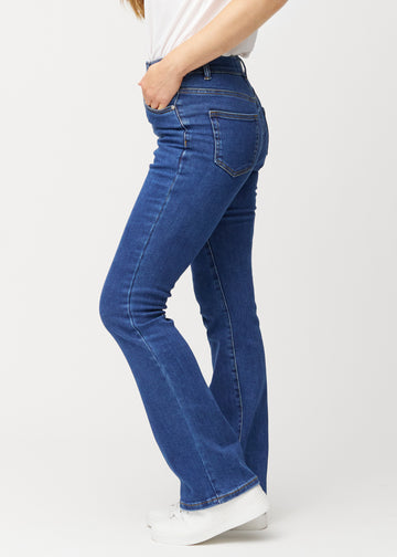 Mörkblå mid-rise bootcutjeans i färgen Oceans. Från sidan på en modell.