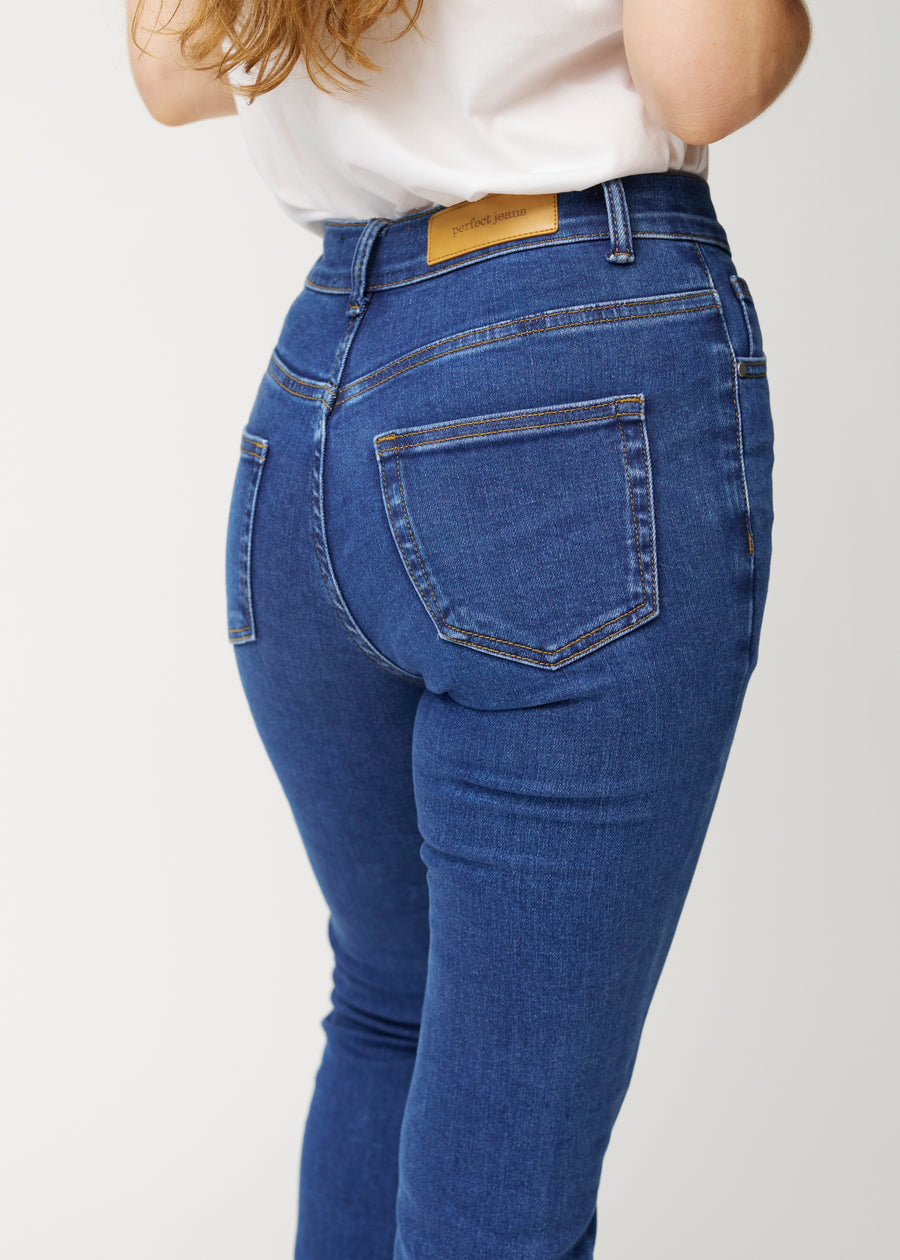 Mörkblå mid-rise bootcutjeans i färgen Oceans. Närbild bakifrån på en modell som visar detaljerna.