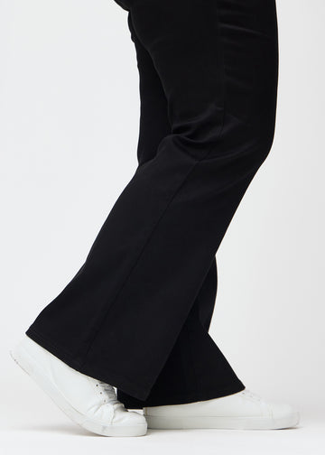 Anklarna på en plus size-modell, så att man kan se den lätta vidden i byxbenet, i en Bootcut-passform.