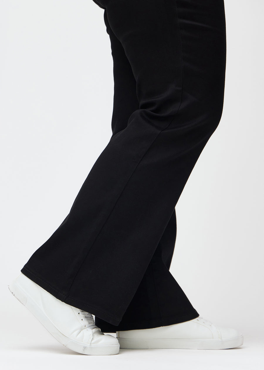 Anklarna på en plus size-modell, så att man kan se den lätta vidden i byxbenet, i en Bootcut-passform.