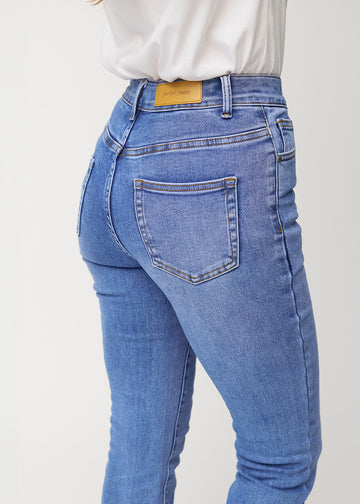 Blå mid-rise bootcutjeans i färgen Rivers. Närbild bakifrån på en modell som visar detaljerna.