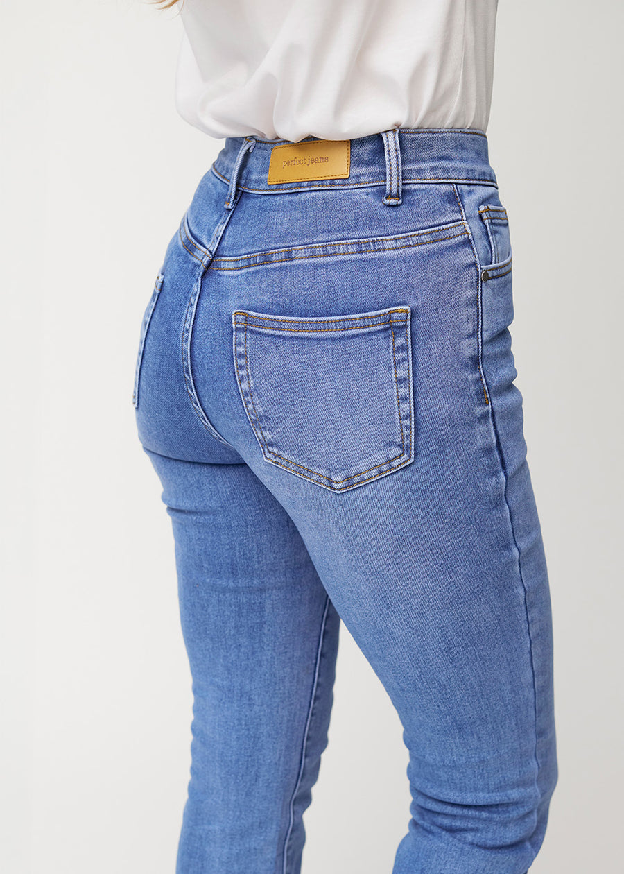 Blå mid-rise bootcutjeans i färgen Rivers. Närbild bakifrån på en modell som visar detaljerna.