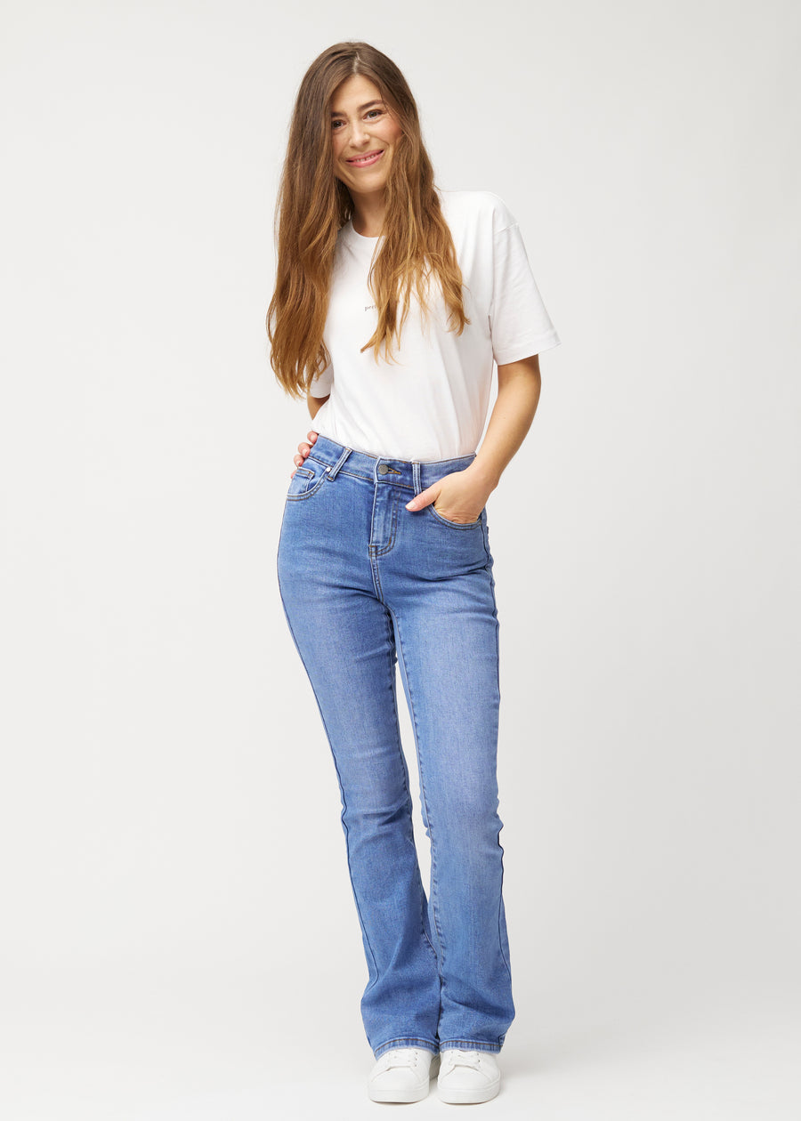 Blå mid-rise bootcutjeans i färgen Rivers. Helbild av en modell i jeansen.