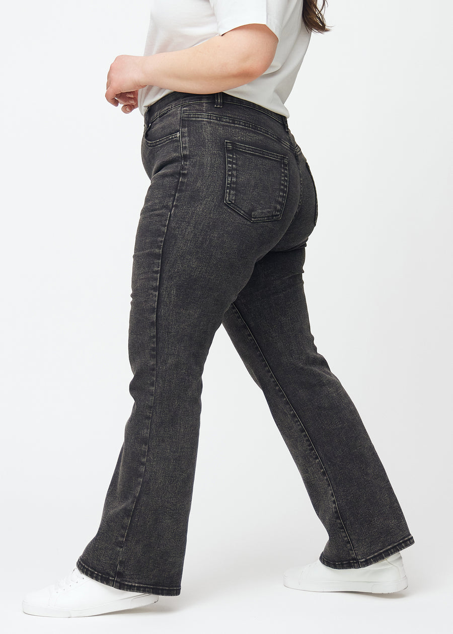Mörkgrå mid-rise bootcutjeans i färgen Shadows. Från sidan på en plus size-modell.