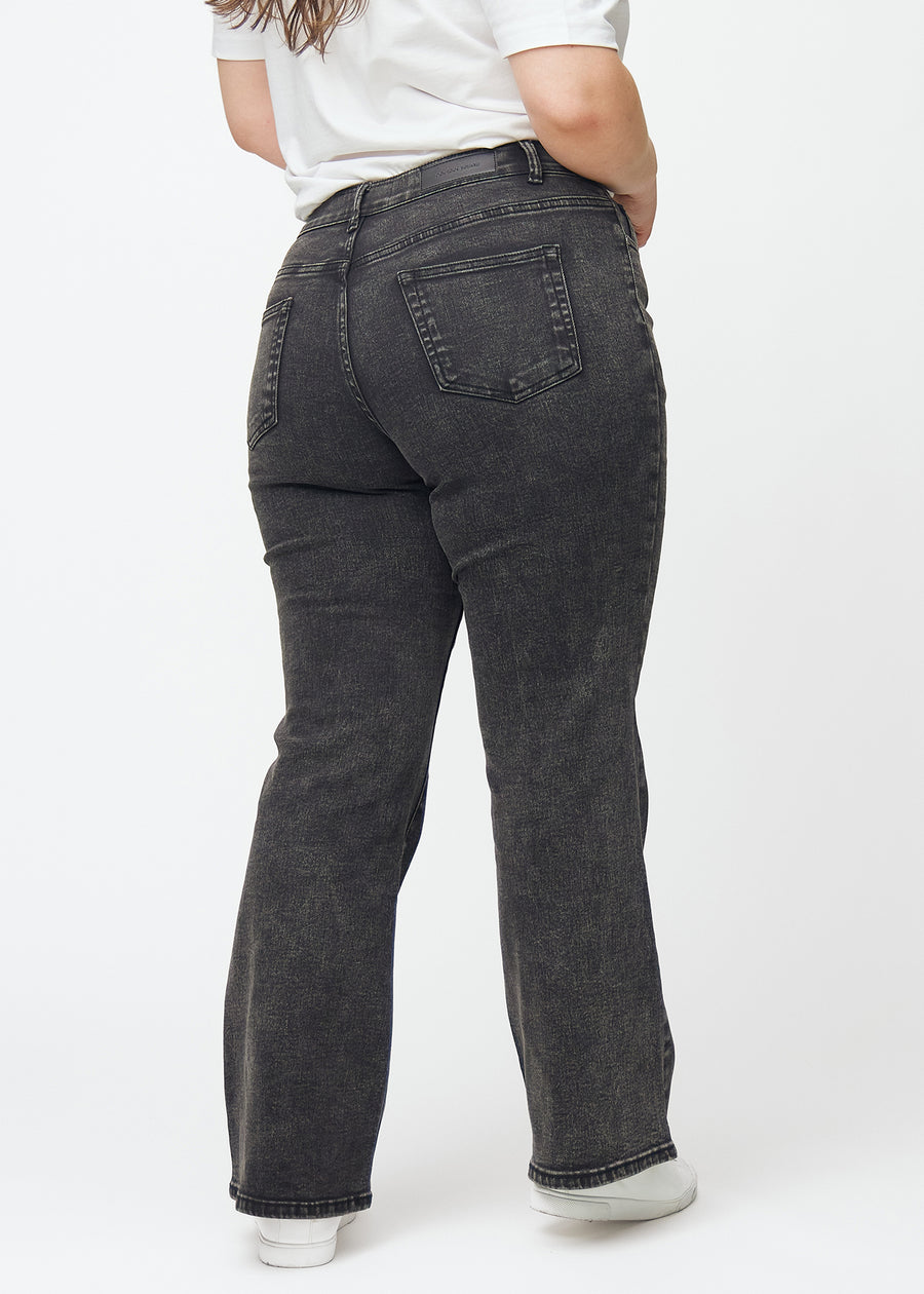 Mörkgrå mid-rise bootcutjeans i färgen Shadows. Bakifrån på en plus size-modell, så att hela passformen syns.