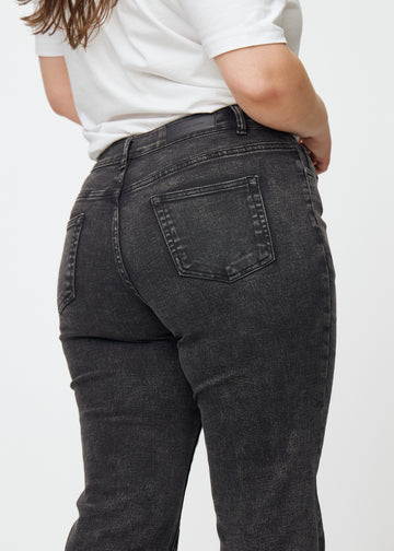 Mörkgrå mid-rise bootcutjeans i färgen Shadows. Närbild bakifrån på en plus size-modell som visar detaljerna.