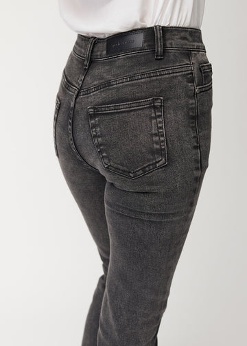 Mörkgrå mid-rise bootcutjeans i färgen Shadows. Närbild bakifrån på en modell som visar detaljerna.