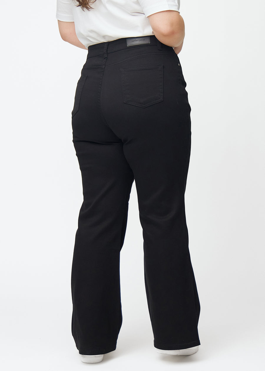 Svarta högmidjade bootcut jeans sedda bakifrån på en plus size-modell, så att man kan se hela produkten.