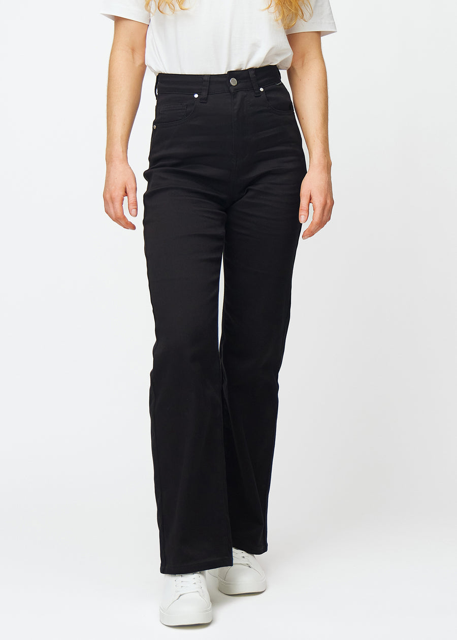 Svarta högmidjade jeans i modellen Ravens, som sitter åt i midjan och har en lös passform med vidd nedtill, sedda framifrån.