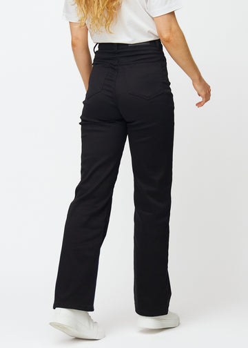 Svarta högmidjade jeans, som sitter åt i midjan och har en lös passform med vidd nedtill, sedda bakifrån för att visa hela produkten.