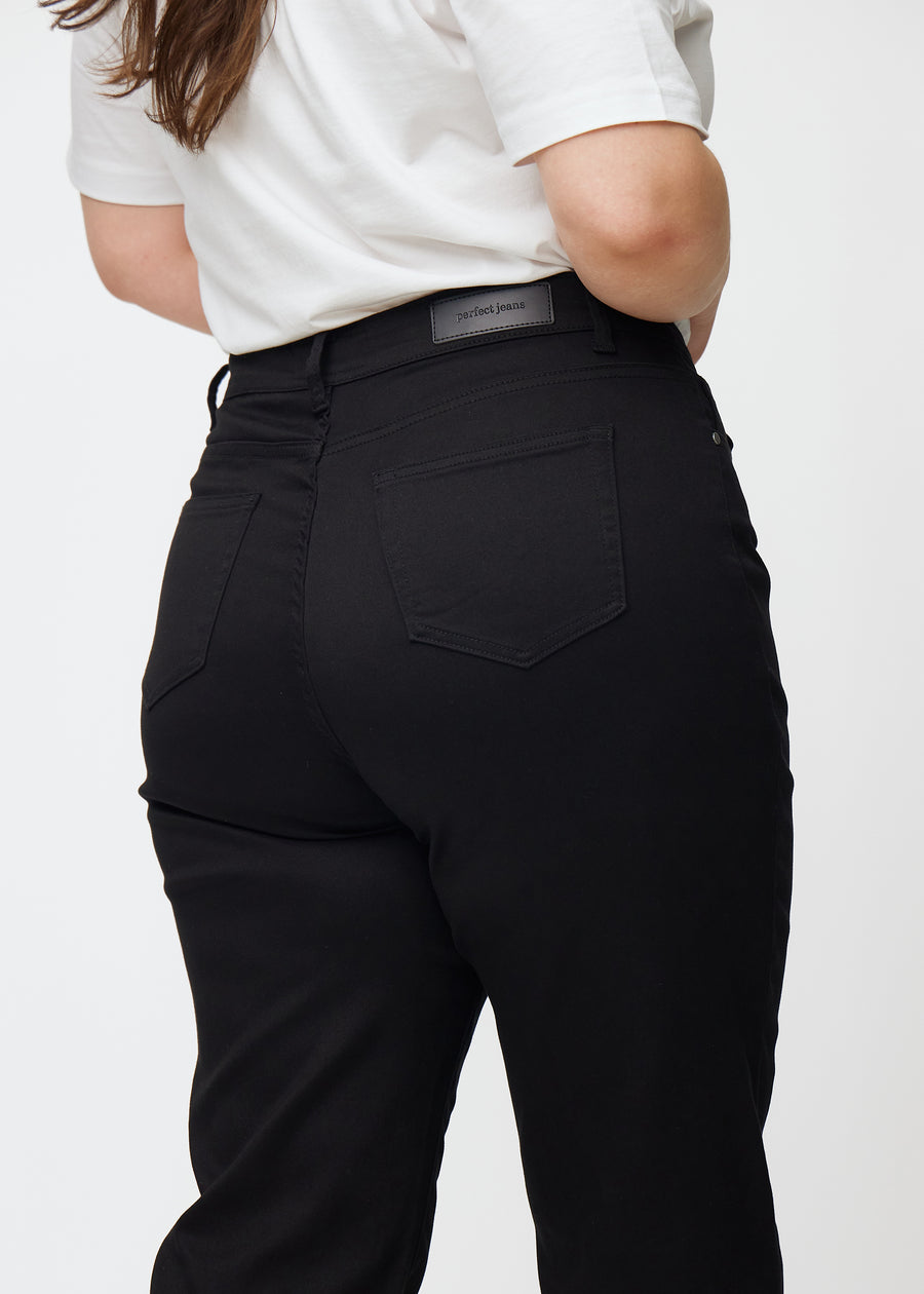 Svarta högmidjade regular jeans sedda bakifrån i närbild på en plus-size-modell för att visa detaljer.
