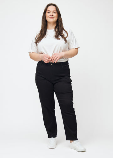 Helbild av en plus-size-modell i svarta högmidjade regular jeans.