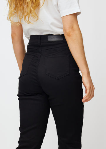 Svarta högmidjade regular jeans sedda bakifrån i närbild för att visa detaljer.