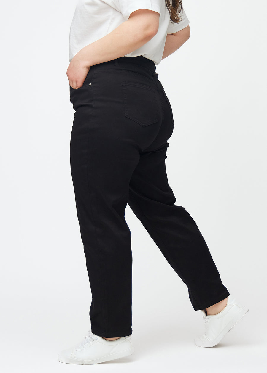Svarta högmidjade regular jeans sedda från sidan på en plus-size-modell.
