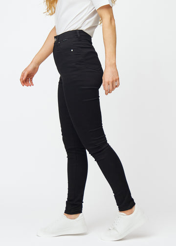 Svarta high rise skinny jeans för kvinnor i färgen Ravens ses från sidan på en modell.