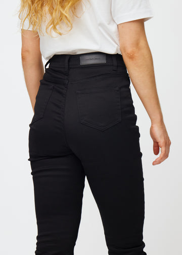 Svarta högmidjade slim jeans sedda bakifrån i närbild för att visa detaljer.