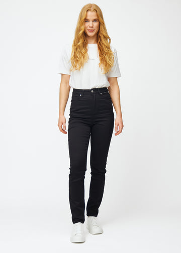 Helbild av modell i svarta högmidjade slim jeans.