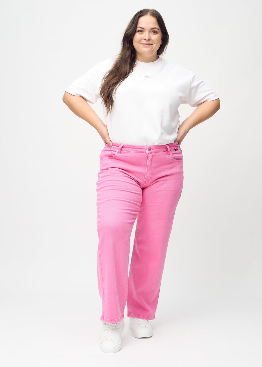 Helbild av en plus size-modell i ljusrosa loose jeans.