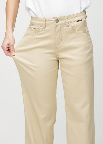 Loose jeans för kvinnor i beige, färgen Gazelles. En modell drar i jeanstyget vid låret för att visa stretchen.