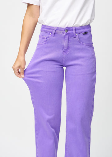 Loose jeans för kvinnor i lila, färgen Lavenders. En modell drar i jeanstyget vid låret för att visa stretchen.
