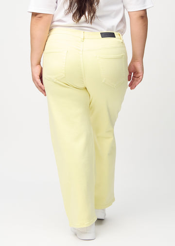 Loose jeans för kvinnor i ljusgul, färgen Lemonades. Bakifrån på en plus size-modell, så att hela den lösa passformen syns.
