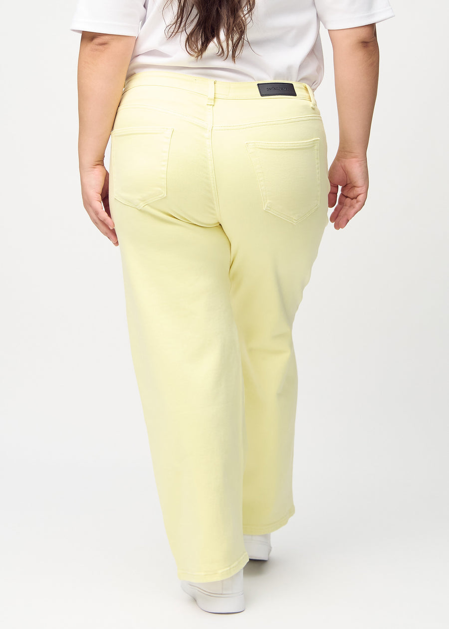 Loose jeans för kvinnor i ljusgul, färgen Lemonades. Bakifrån på en plus size-modell, så att hela den lösa passformen syns.